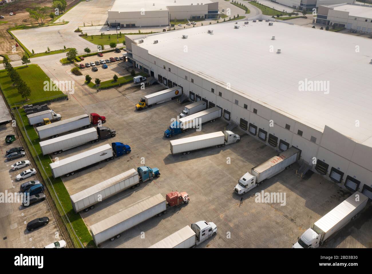 Trucks werden im McLane Global Distribution Center eingesetzt, wo Mitarbeiter Lebensmittelboxen für Studenten in ländlichen Schulen packen, die aufgrund der COVID-19-Pandemie am 26. März 2020 in Houston, Texas geschlossen sind. McLane Global stellt zusammen mit dem US-Landwirtschaftsministerium, PepsiCo und Baylor Collaborative fast 1.000.000 Mahlzeiten pro Woche für bedürftige Studenten bereit. Stockfoto