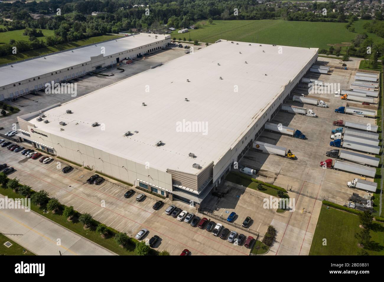 Trucks werden im McLane Global Distribution Center eingesetzt, wo Mitarbeiter Lebensmittelboxen für Studenten in ländlichen Schulen packen, die aufgrund der COVID-19-Pandemie am 26. März 2020 in Houston, Texas geschlossen sind. McLane Global stellt zusammen mit dem US-Landwirtschaftsministerium, PepsiCo und Baylor Collaborative fast 1.000.000 Mahlzeiten pro Woche für bedürftige Studenten bereit. Stockfoto
