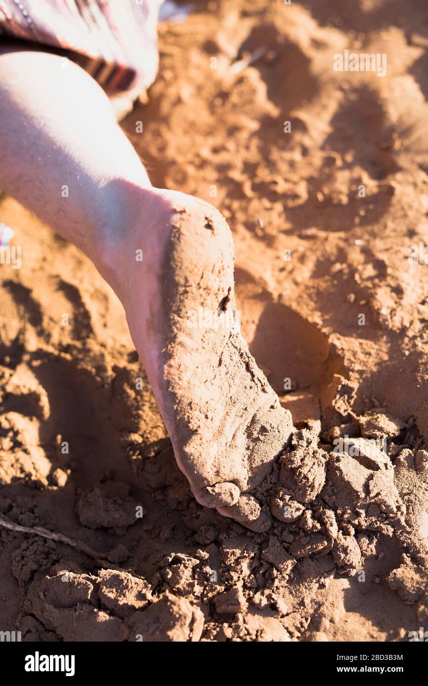 Fuß einer Person stumpft auf Wüstenlehm in M'Hamid El Ghizlane, Marokko. Stockfoto