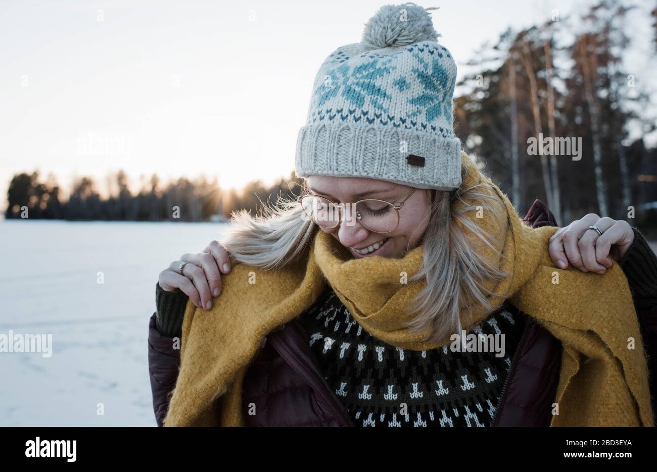 Porträt einer lächelnden Frau eingewickelt warm Wandern auf einem gefrorenen See Stockfoto