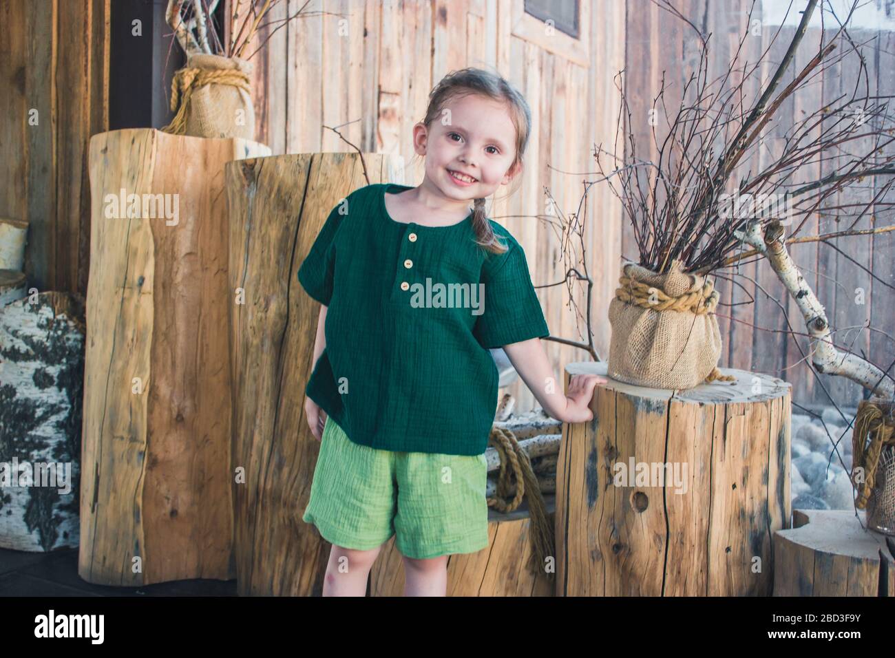 Porträt eines fröhlichen, süßen, emotionalen kleinen Mädchens in ländlicher Moselkleidung an einem Sommertag. Stockfoto