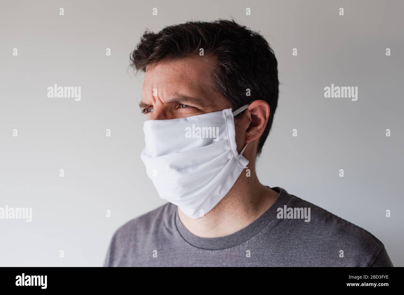 Mann trägt hausgemachte Tuch Gesichtsmaske während Covid 19 Pandemie. Stockfoto