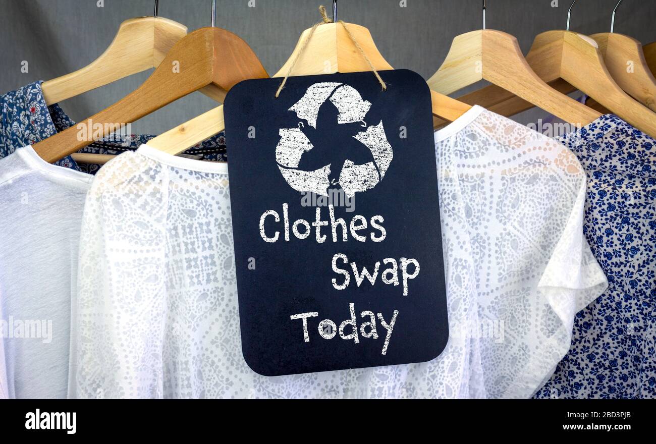 Kleidung Tauschen und recyceln Kleidung Symbol auf Kreidetafel mit hängenden Shirts zu tauschen, nachhaltige Mode und Null Abfall, recyceln Kleidung und Textilien Stockfoto