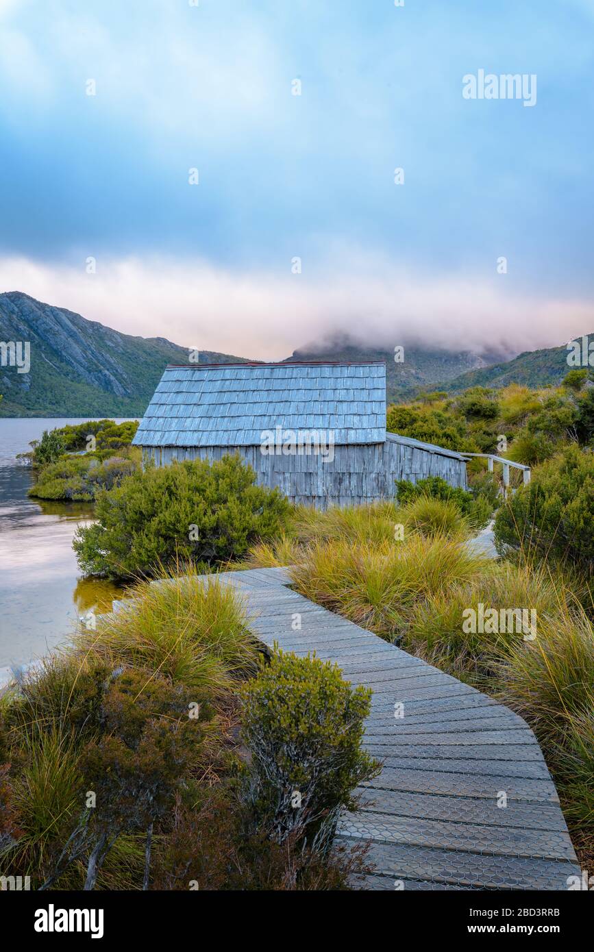 Kultiger Blick auf die Holzstege, die zum Holzboathaus am Dove Lake führt, im Cradle Mountain National Park in Tasmanien, Australien. Stockfoto