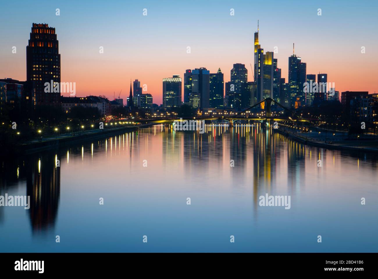 06. April 2020, Hessen, Frankfurt am Main: Die Bankensilhouette Frankfurts spiegelt sich in den Gewässern des Mains wider. Trotz frühlingsähnlicher Temperaturen sind die Straßen und Brücken der Stadt wegen der Bewegungseinschränkungen durch die Corona-Pandemie nicht sehr ausgelastet. Foto: Boris Roessler / dpa Stockfoto