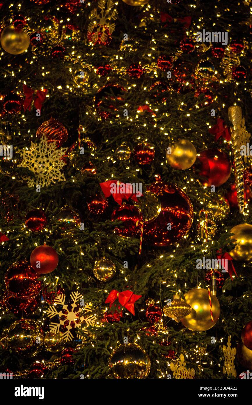 Rote und goldene Ornamente auf einem geschmückten Weihnachtsbaum. Stockfoto