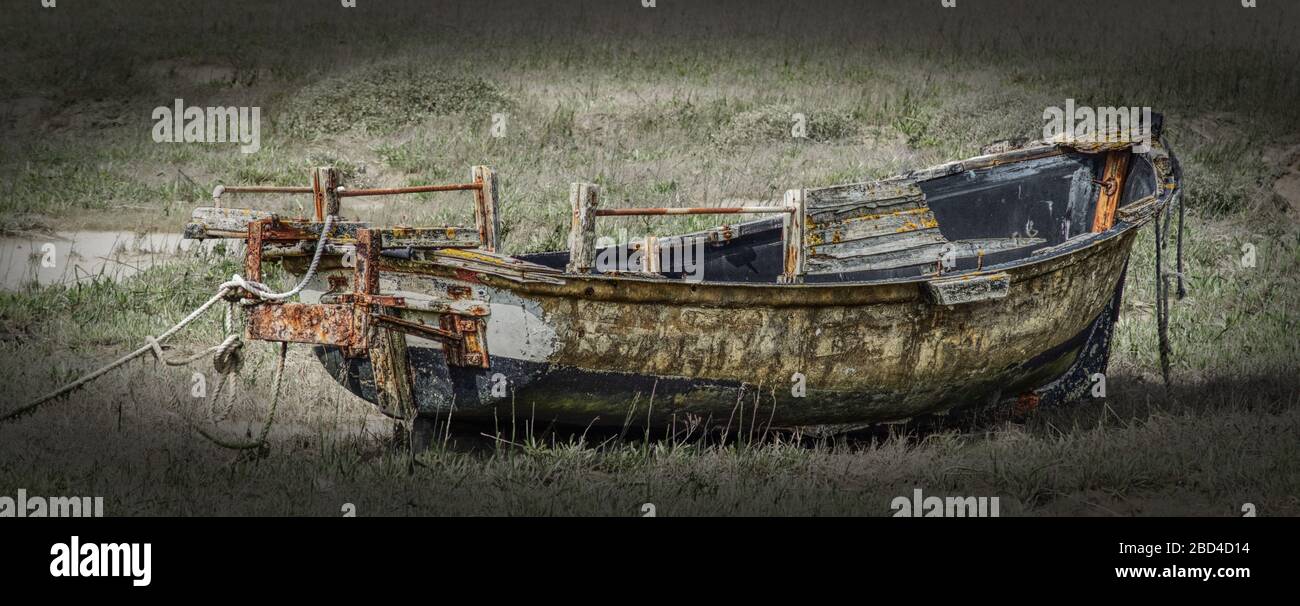 Das zerstörte Boot sitzt auf dem müde aufradenen Flussbett Stockfoto