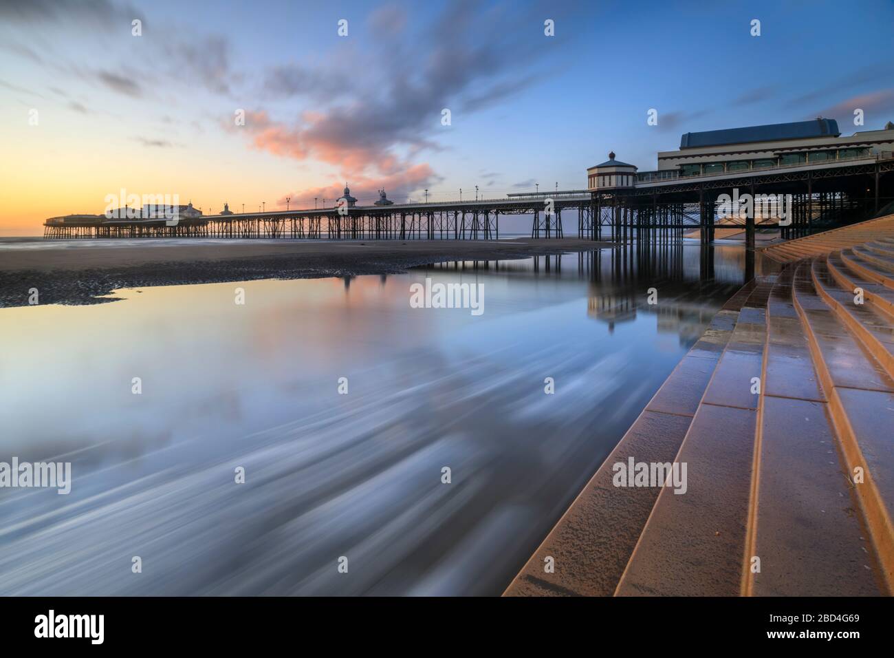 Der North Pier in Blackpool wurde bei Sonnenuntergang von der Meereswand erfasst Stockfoto