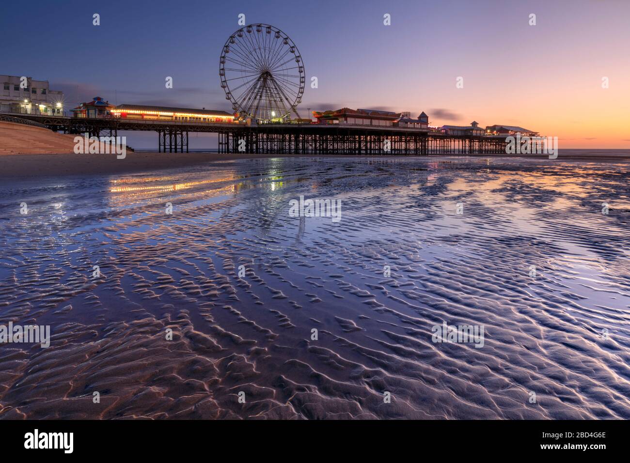 Der Central Pier in Blackpool wurde während der Dämmerung vom Strand aus eingefangen. Stockfoto