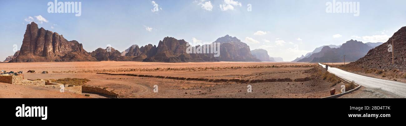 Sieben Säulen der Weisheit, wie sie im Eingang zu Wadi Rum gesehen wurden, schützten das Gebiet vor dem Besucherzentrum. Kleine Geländewagen im Vordergrund geparkt Stockfoto