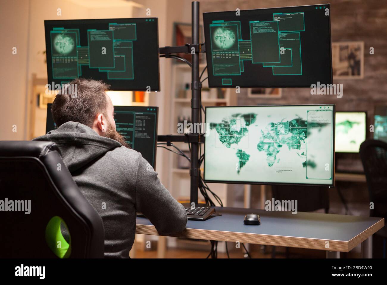 Rückansicht des gefährlichen Hackers, der eine Malware eingibt, um einen Regierungsserver zu hacken. Stockfoto
