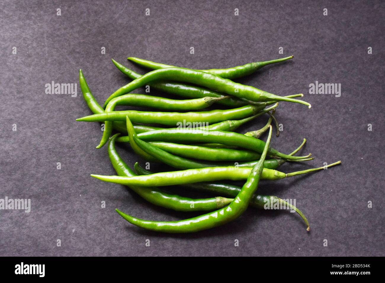 Frische grüne Chilies auf schwarzem Hintergrund oben Ansicht Nahaufnahme Stock Foto Bild Stockfoto