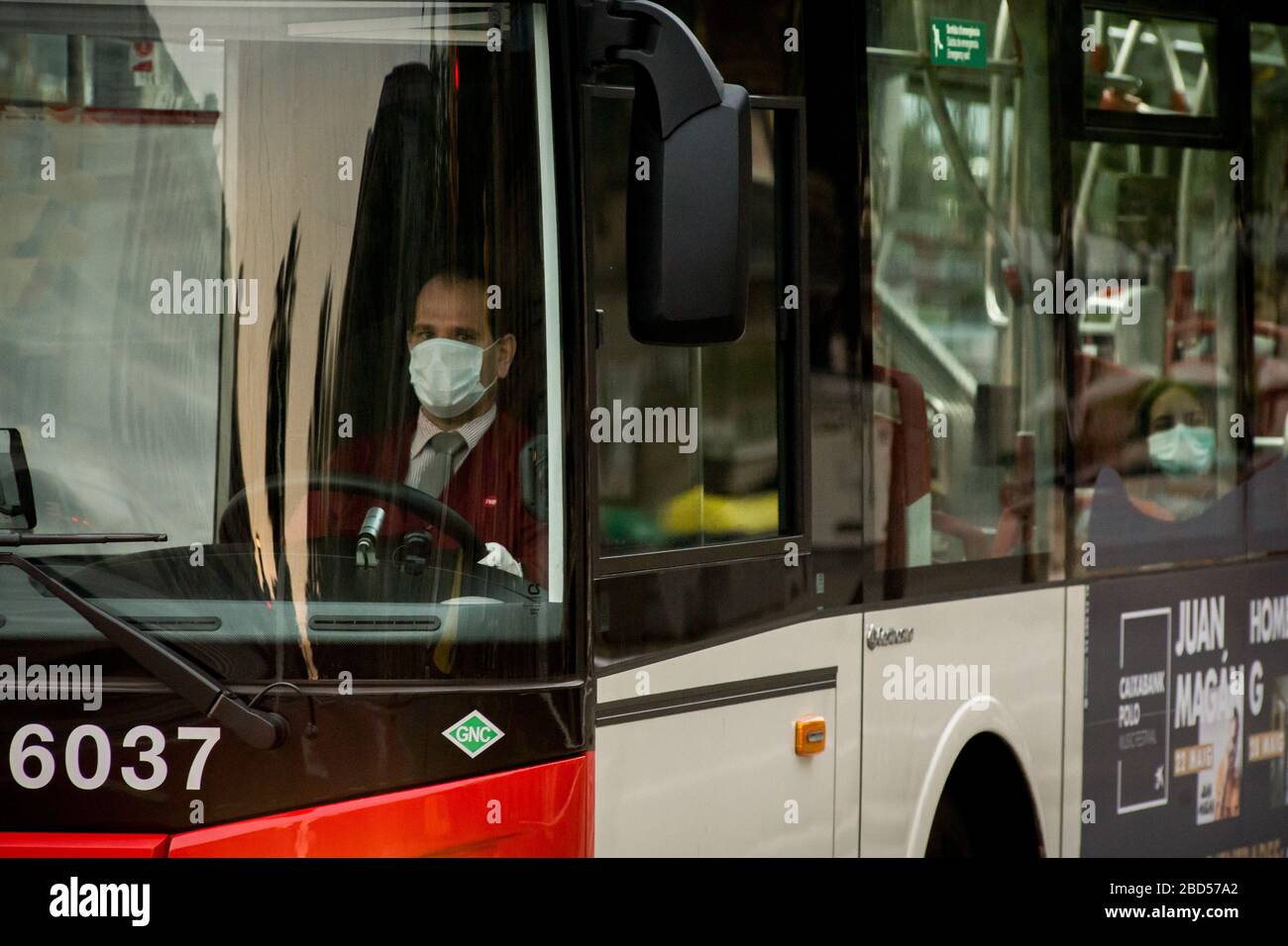 Barcelona, Katalonien, Spanien. April 2020 - EIN Busfahrer, der eine Gesichtsschutzmaske trägt, wartet darauf, dass die Ampel in Barcelona grün wird. Nach viertäglichem Sturz steigen die täglichen Coronavirus-Todesfälle in Spanien auf 743. Die Gesamtzahl der Todesopfer im Land liegt jetzt bei 13.798, bei 140.510 bestätigten Infektionen. Credit:Jordi Boixareu/Alamy Live News Stockfoto