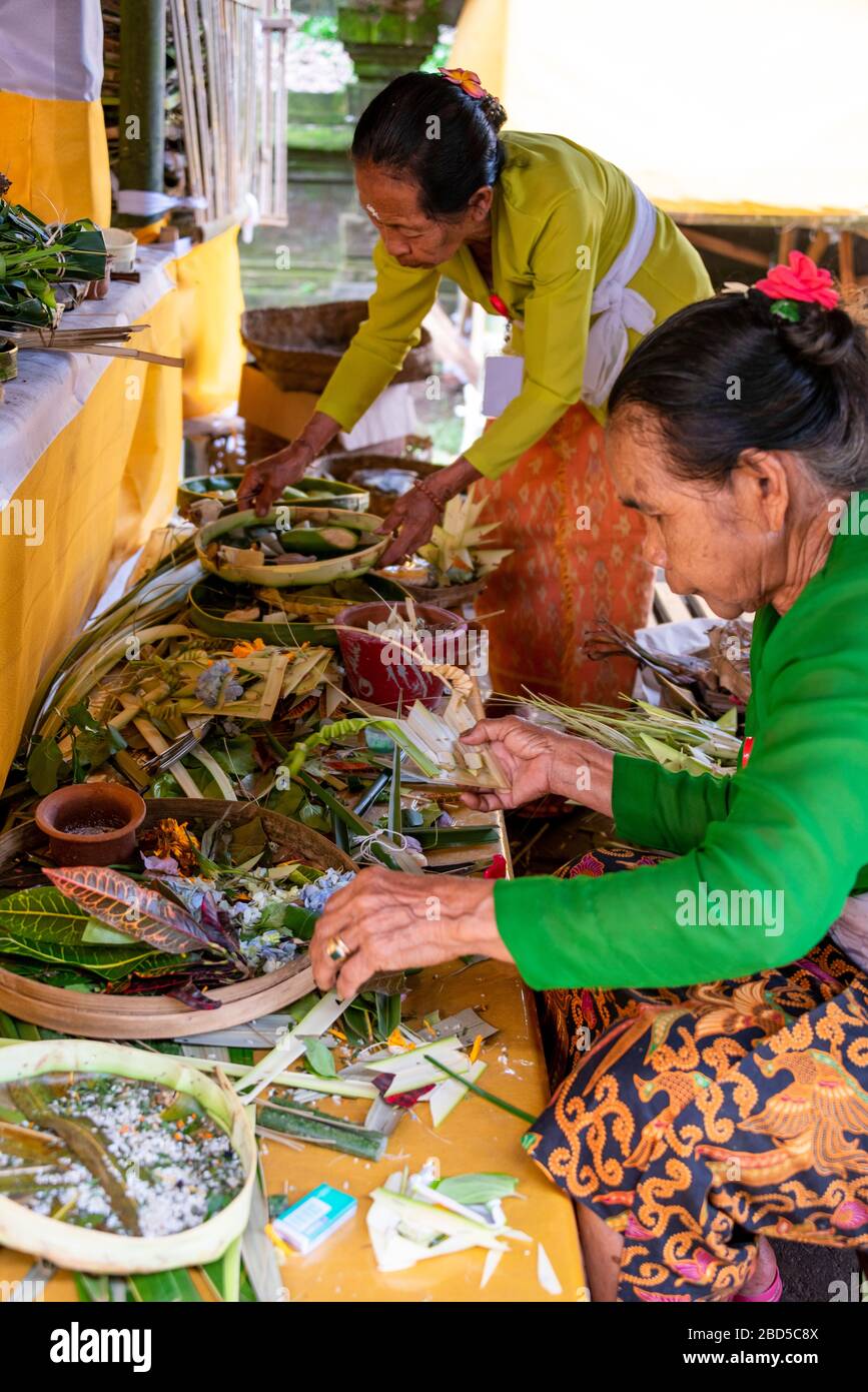 Vertikaler Blick auf Damen, die in einem Tempel in Bali, Indonesien Dekorationen zu bieten haben. Stockfoto