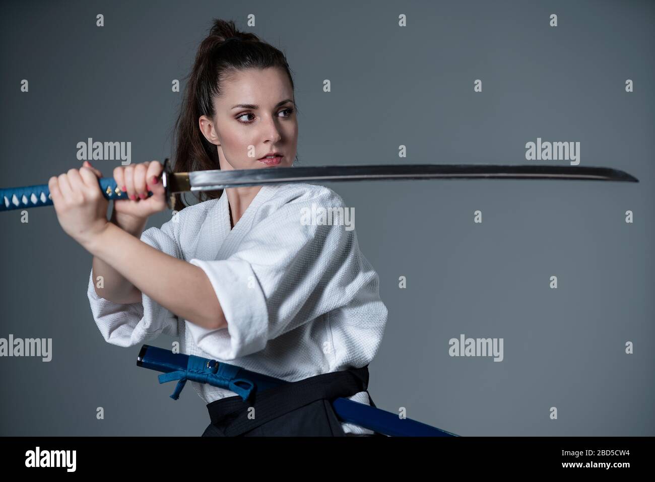 Eine junge Frau mit Katana, die bereit ist, Aikido zu üben Stockfoto