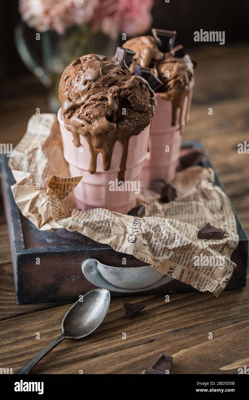 Schokoladenjoghurt schmeckt hausgemachte Eiskugeln in einer Tasse, Sommersonden auf rustikalem Hintergrund Stockfoto