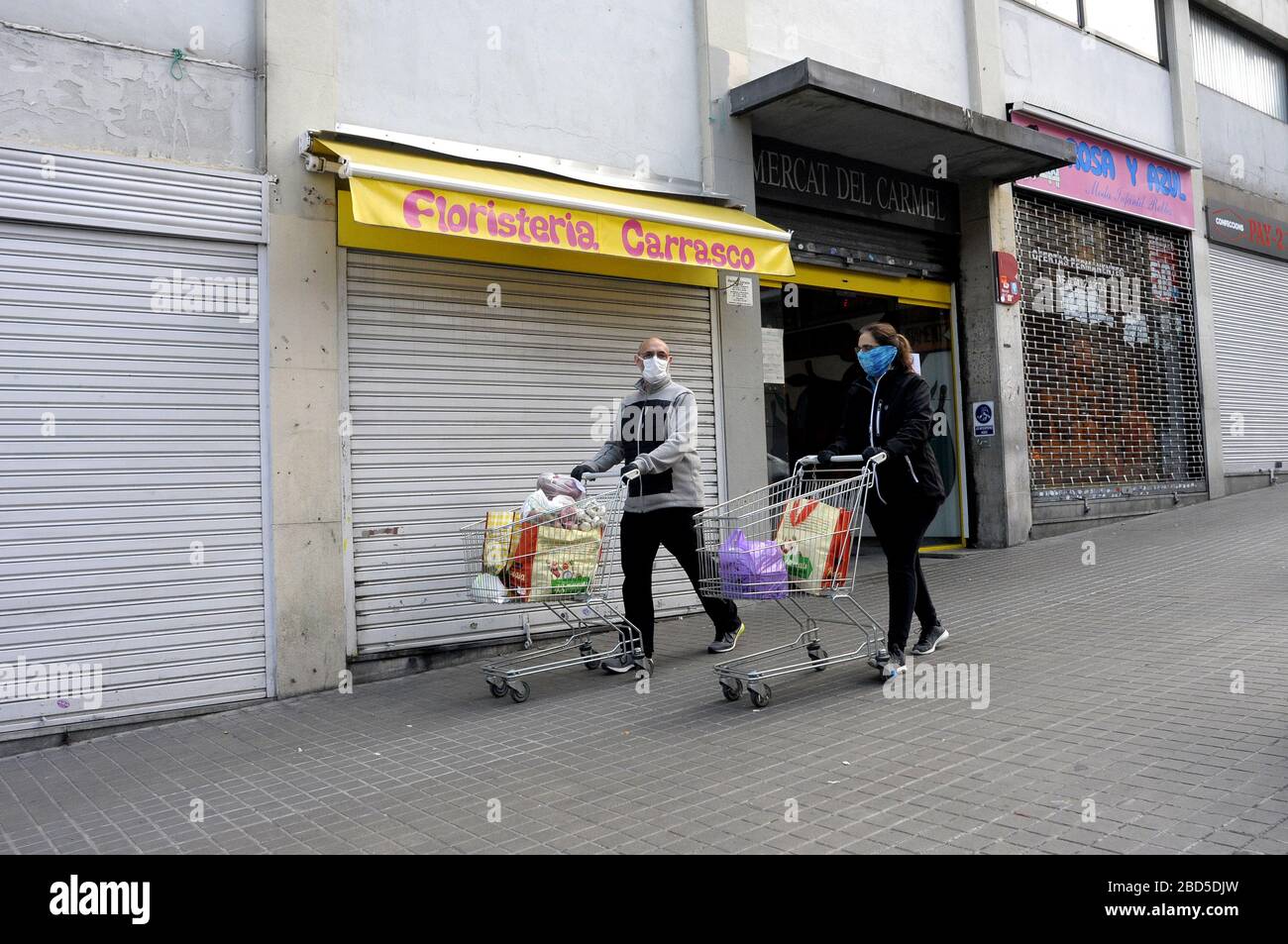 Paar Karren mit Troley-Essen vom Carmel-Lebensmittelmarkt, während Covid 19 Barcelona, Spanien Stockfoto