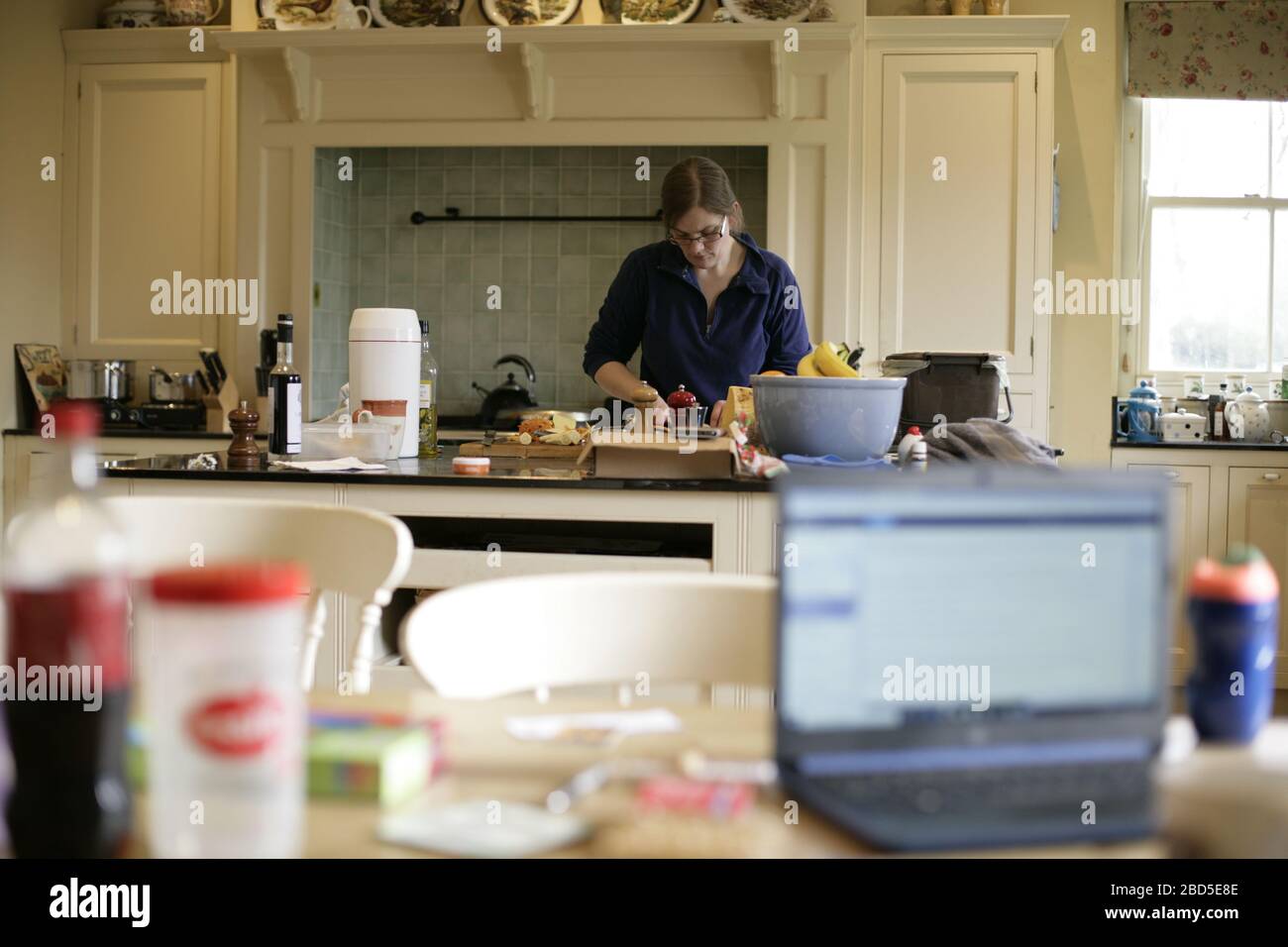 Mutter bereitet und kocht Familienessen in der Küche während der Arbeit von zu Hause während der Selbstisolation - 2020 COVID-19 Coronavirus Pandemie Stockfoto