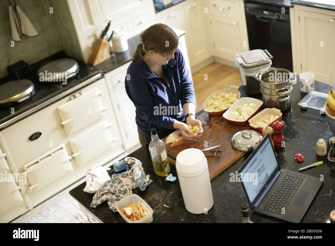 Mutter bereitet und kocht Familienessen und Mahlzeiten in der Küche während der Arbeit von zu Hause während der Selbstisolation - 2020 COVID-19 Coronavirus Pandemie Stockfoto