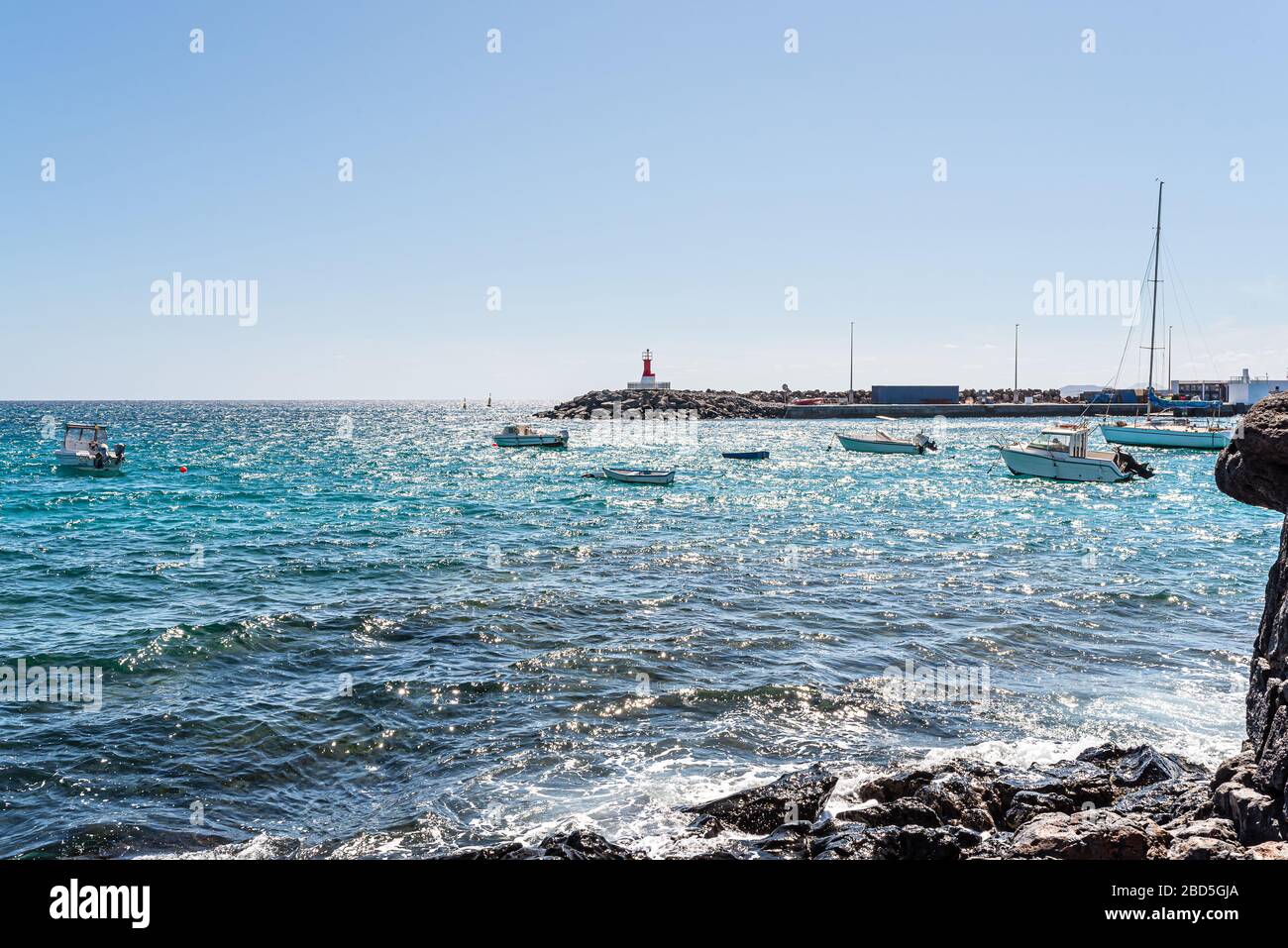 Kleine Boote auf dem Meer in der Nähe von Playa Blanca, Lanzarote Fährterminal gegen den hellblauen Himmel Stockfoto