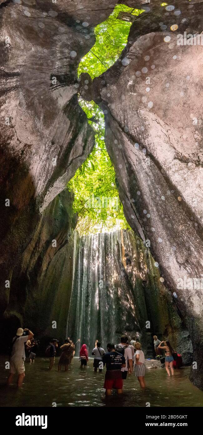 Vertikaler Blick auf die Touristen an den Tukad Cepung-Wasserfällen in Bali, Indonesien. Stockfoto