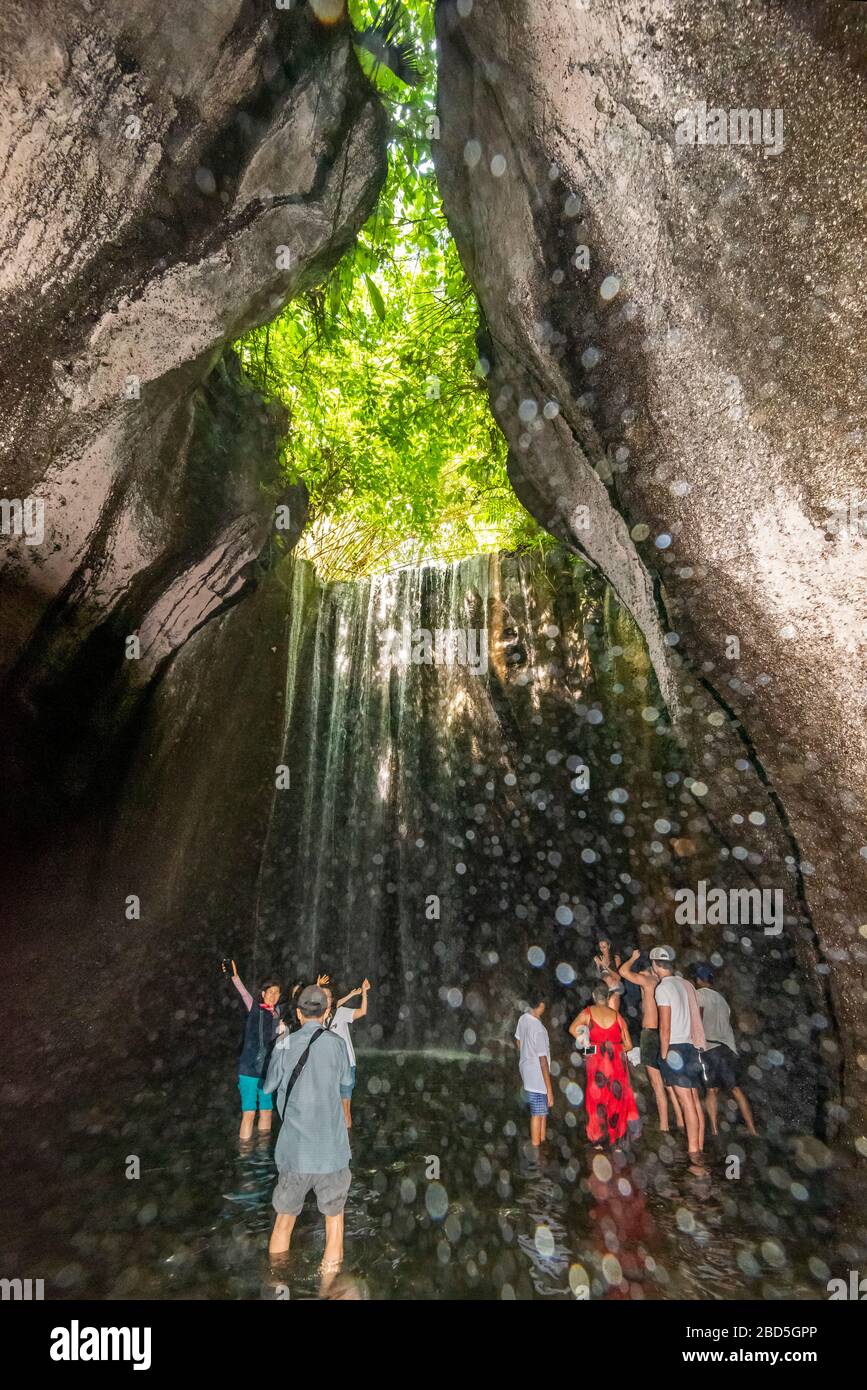 Vertikaler Blick auf die Touristen an den Tukad Cepung-Wasserfällen in Bali, Indonesien. Stockfoto