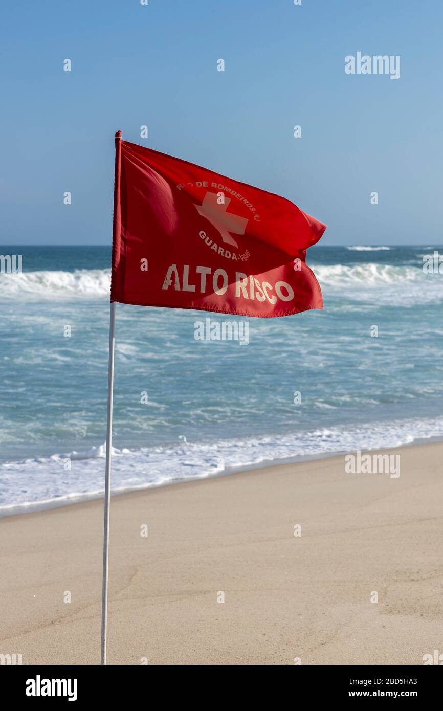 Leuchtende rote Warnfahne am unberührten Leblon-Strand mit Meer im  Hintergrund. ÜBERSETZUNG: FEUERWEHR. RETTUNGSSCHWIMMER. HOHES RISIKO'  Stockfotografie - Alamy