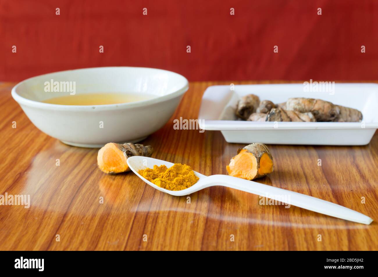 Tischlöffel aus reinem turmerischem Haldi-Pulver. Haldi-turmmilchrezept. Coronavirus anti-virale entzündliche Lebensmittel und Getränke Hintergrund. Gesundheitsfürsorge nür Stockfoto