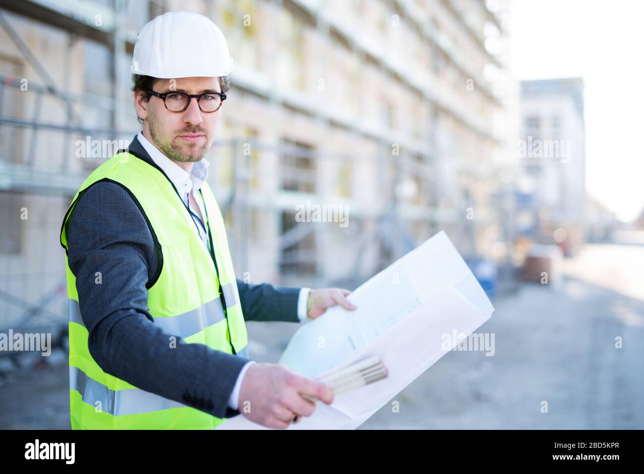 Junger und attraktiver Architekt / Bauingenieur bei der Arbeit auf einer Baustelle Stockfoto