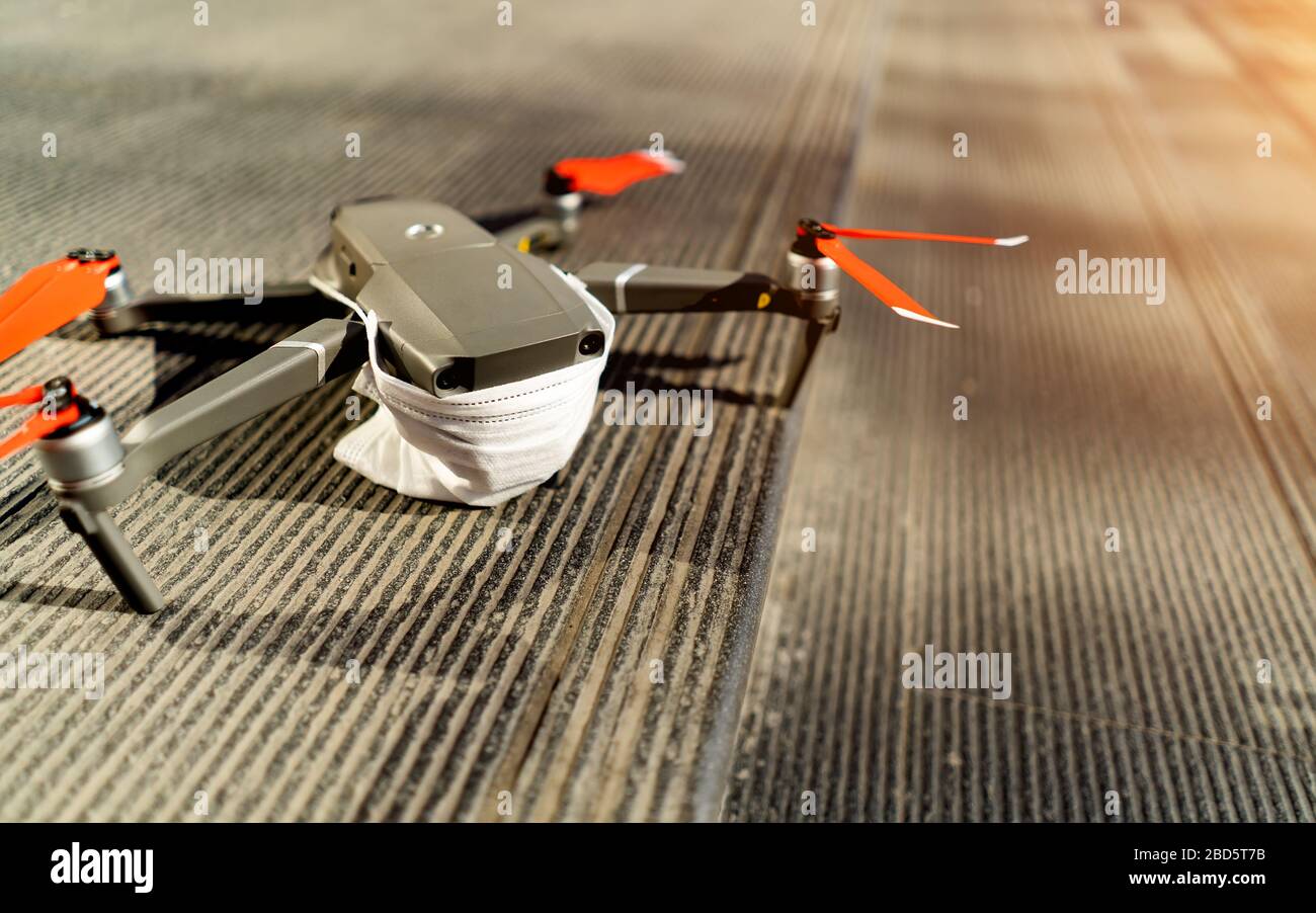 Drohnen verbotene Konzeption: Ausgeklappte Drohne mit medizinischer Gesichtsmaske. Keine Flugzone Stockfoto