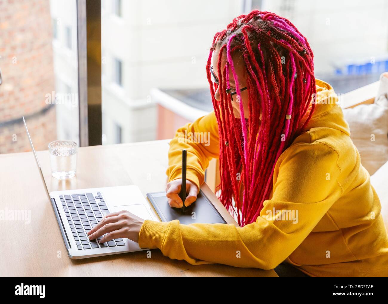 Digitales Nomadenkonzept. Freiberuflicher Girl-Mitarbeiter, der im Café mit Laptop arbeitet. Stockfoto