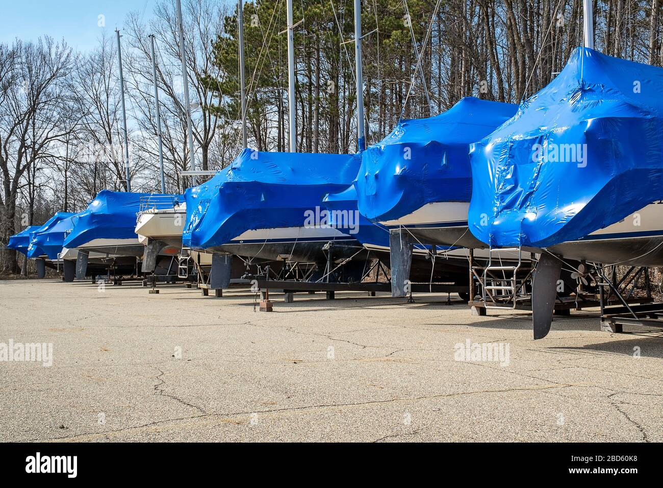 Reihe von Booten mit blauer Schrumpfverpackung im Außenlager Stockfoto