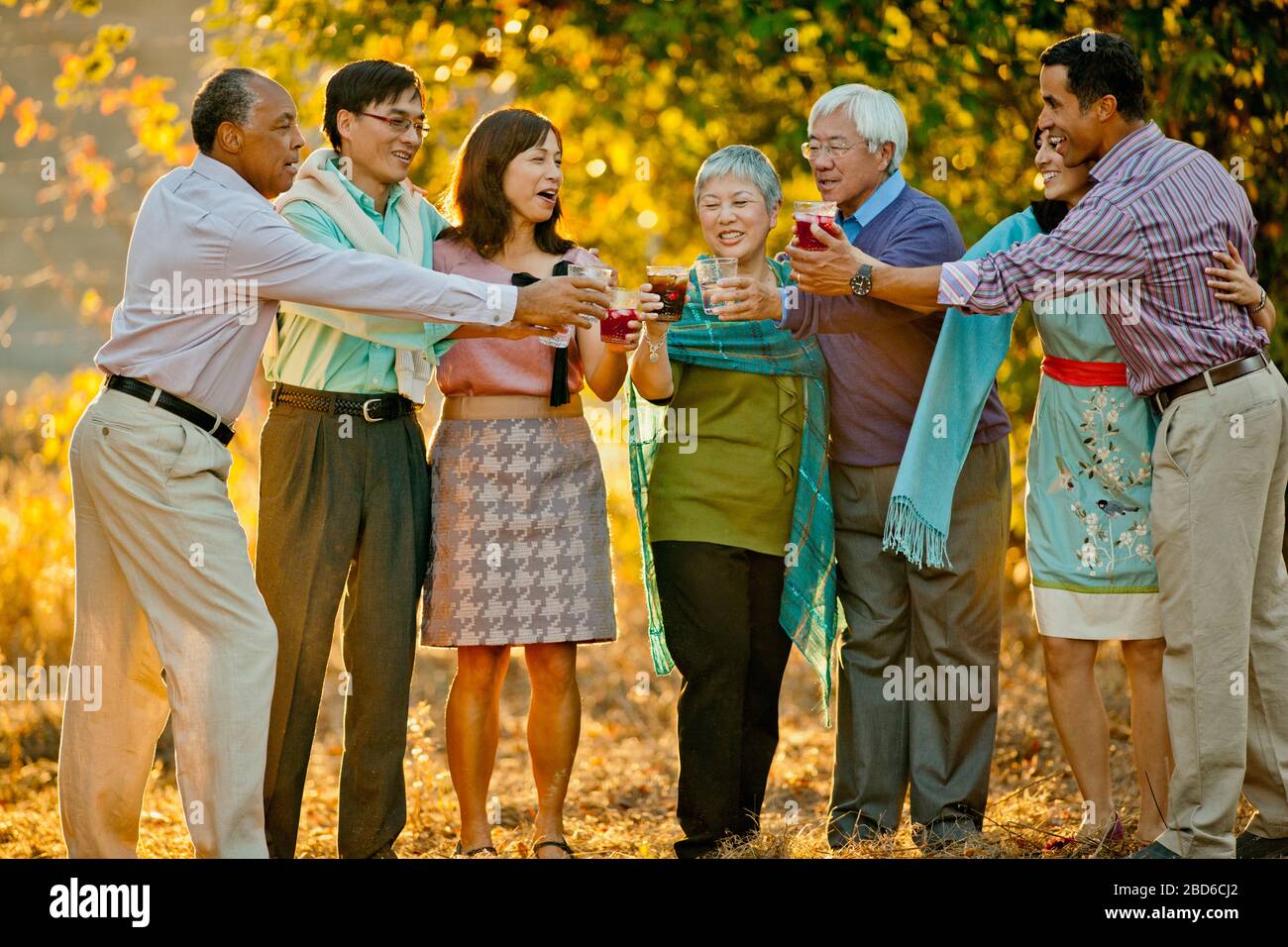 Lächelnd Gruppe von Freunden feiern mit Getränken in einem Hinterhof. Stockfoto