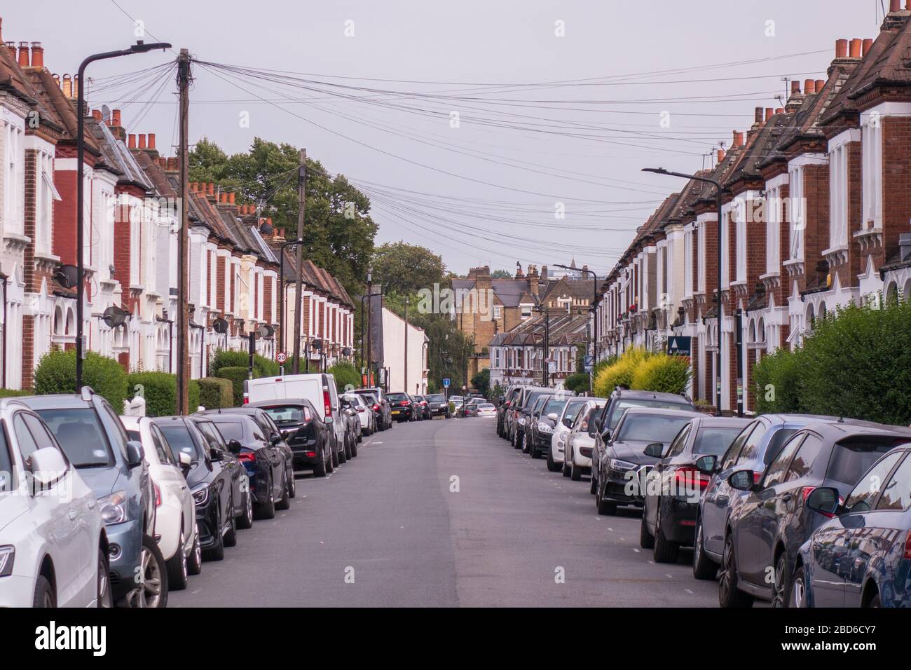 Eine Straße mit typischen britischen Häusern mit Straßenparkplätzen Stockfoto