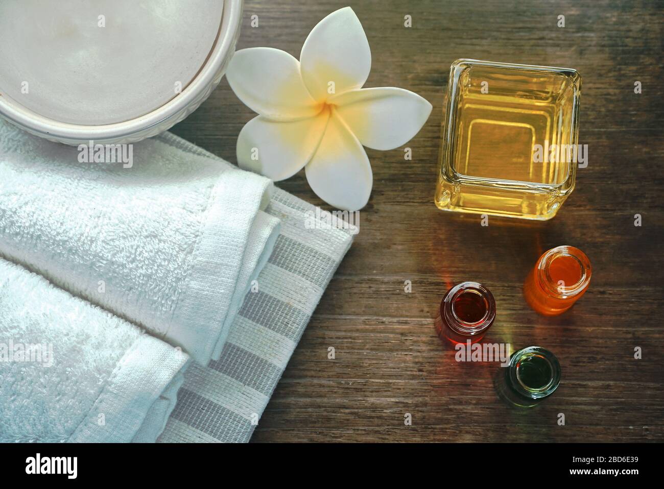 Topview Handtuch und Aromaöl und flüssige Seife schmücken mit weißer Blume auf dem Holztisch, Spa-Set-Konzept. Stockfoto