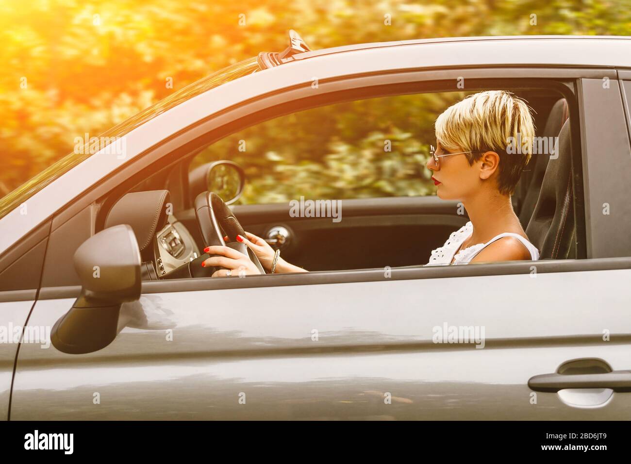 Junge hübsche modische Frau posiert auf einem Auto. Konzept junger Lifestyle. Stockfoto