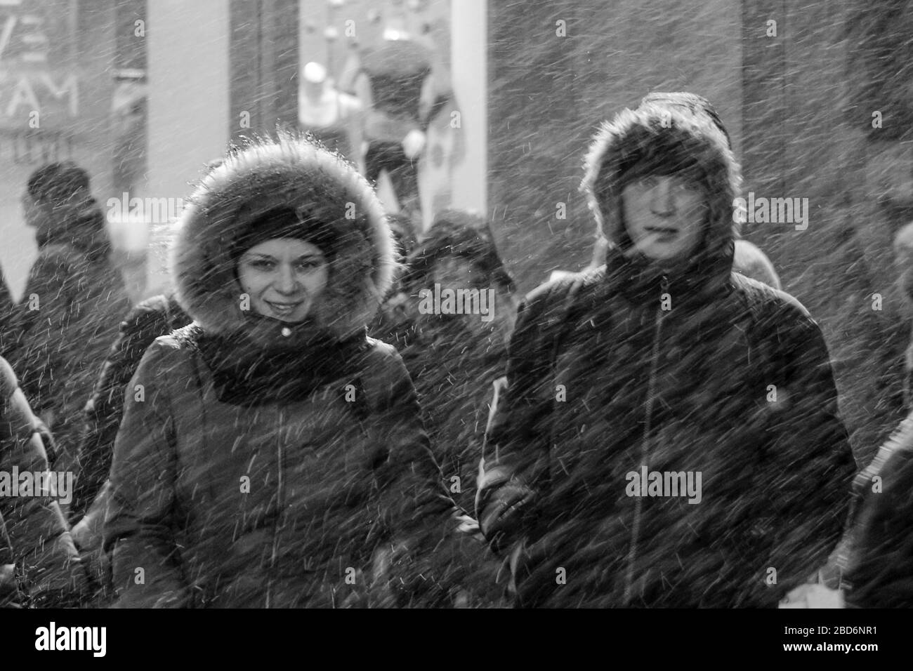 Junges Paar in Winterkleidung am Time Square während Schneesturm in Manhattan, New York City, Vereinigte Staaten von Amerika Stockfoto