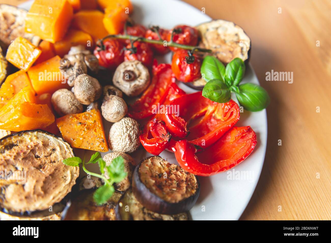 Einfaches gesundes Dinner mit Detox aus verschiedenen Gemüsesorten wie Aubergine, rotem Pfeffer, Kirschtomaten und Butternusskürbis Stockfoto