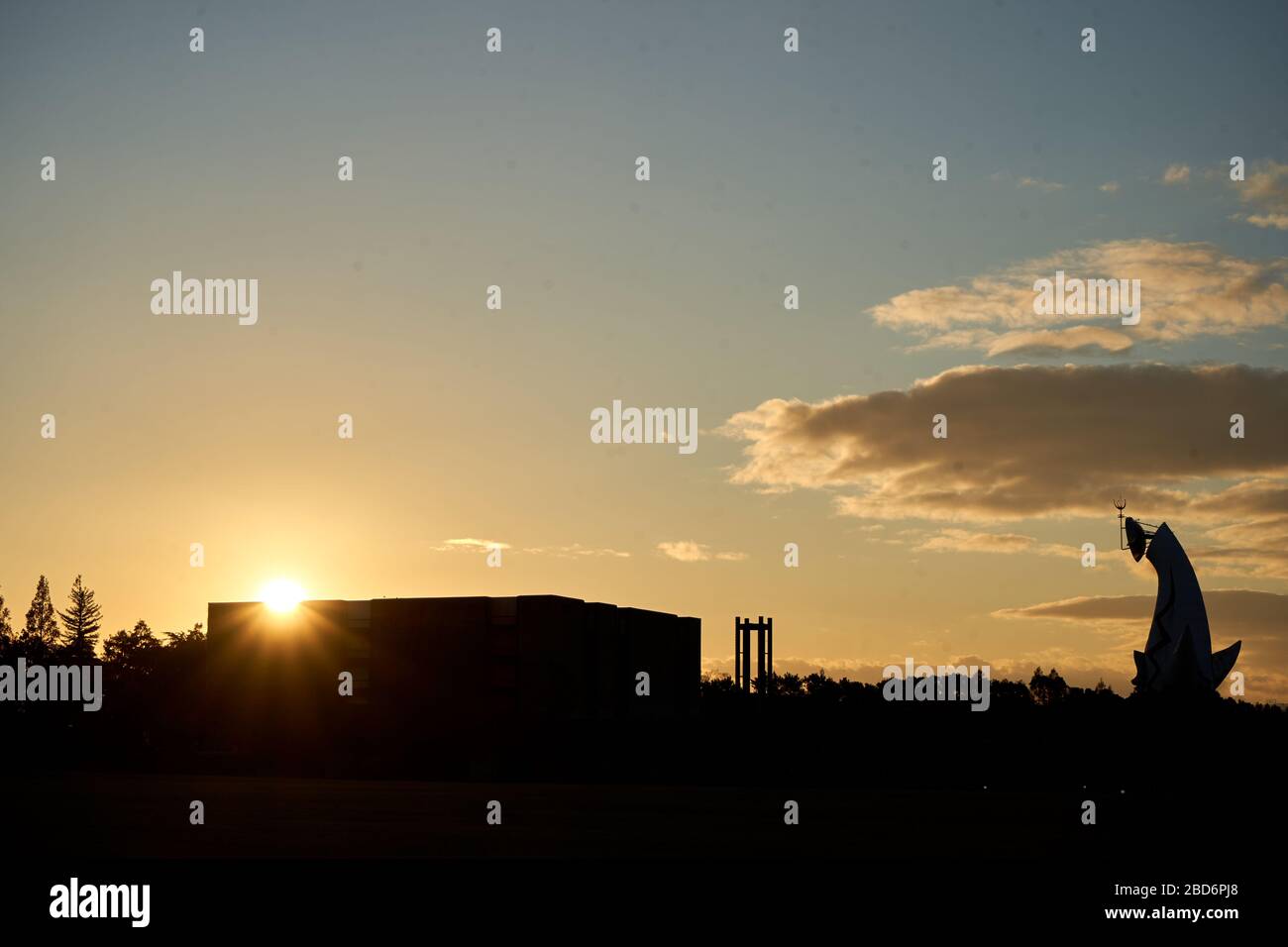 Silhouette des Gebäudes und riesige Skulptur während des Sonnenuntergangs Stockfoto