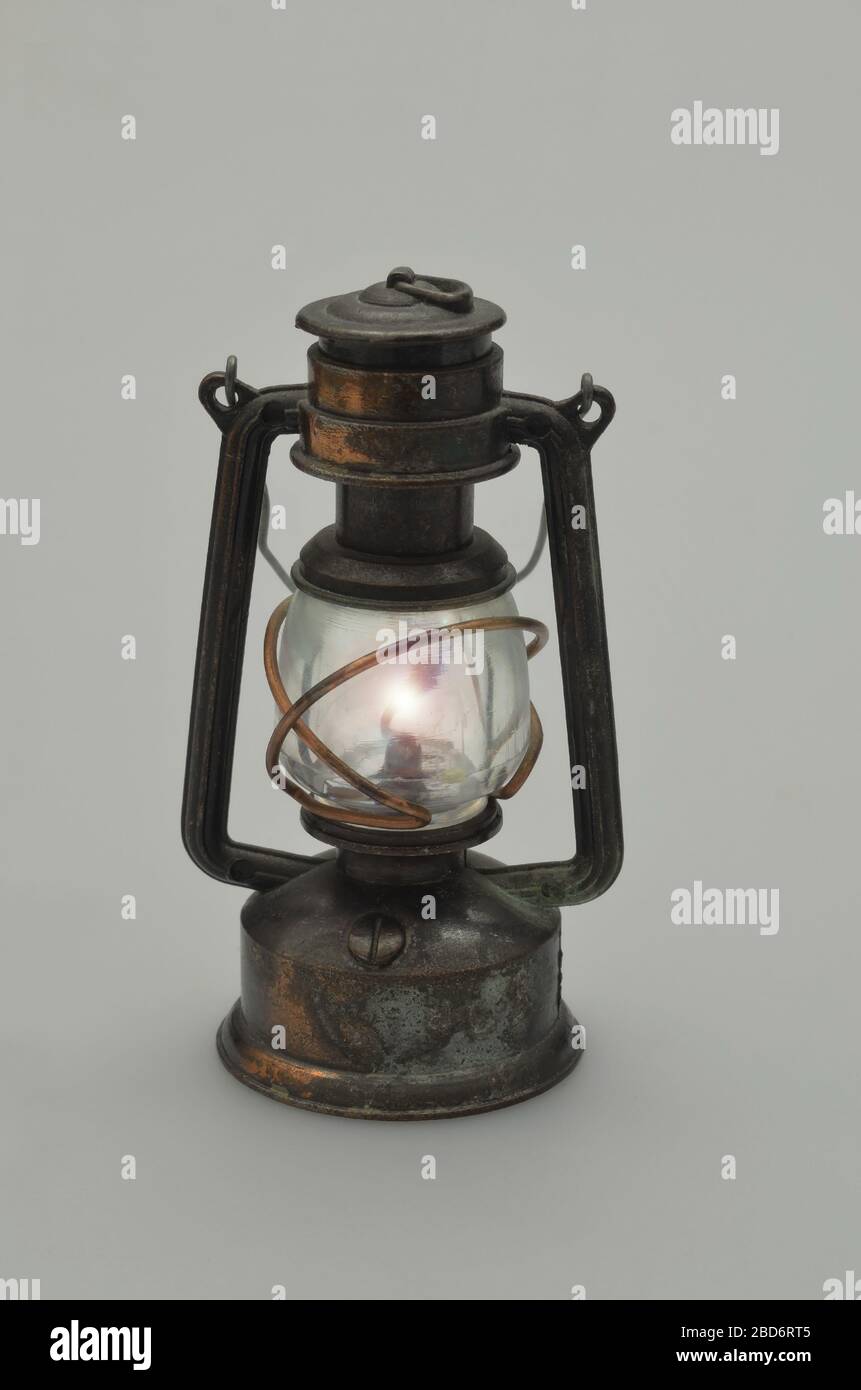 Retro-Öllampe, beleuchtet, Nahaufnahme, isoliert auf weißem Hintergrund, vertikal Stockfoto