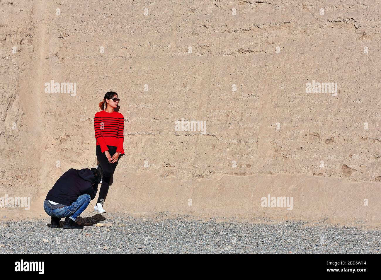 Fotoshooting im Jiayu Pass: Schwarz-rot gekleidetes Modell gegen die Wand-Jiayuguan-Gansu-China-0781 Stockfoto