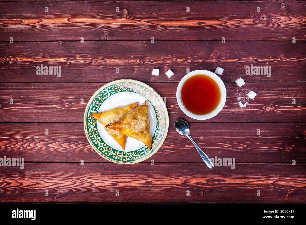 Teller mit köstlichen Samosas oder Samsa mit Tee auf Holzgrund. Draufsicht Stockfoto