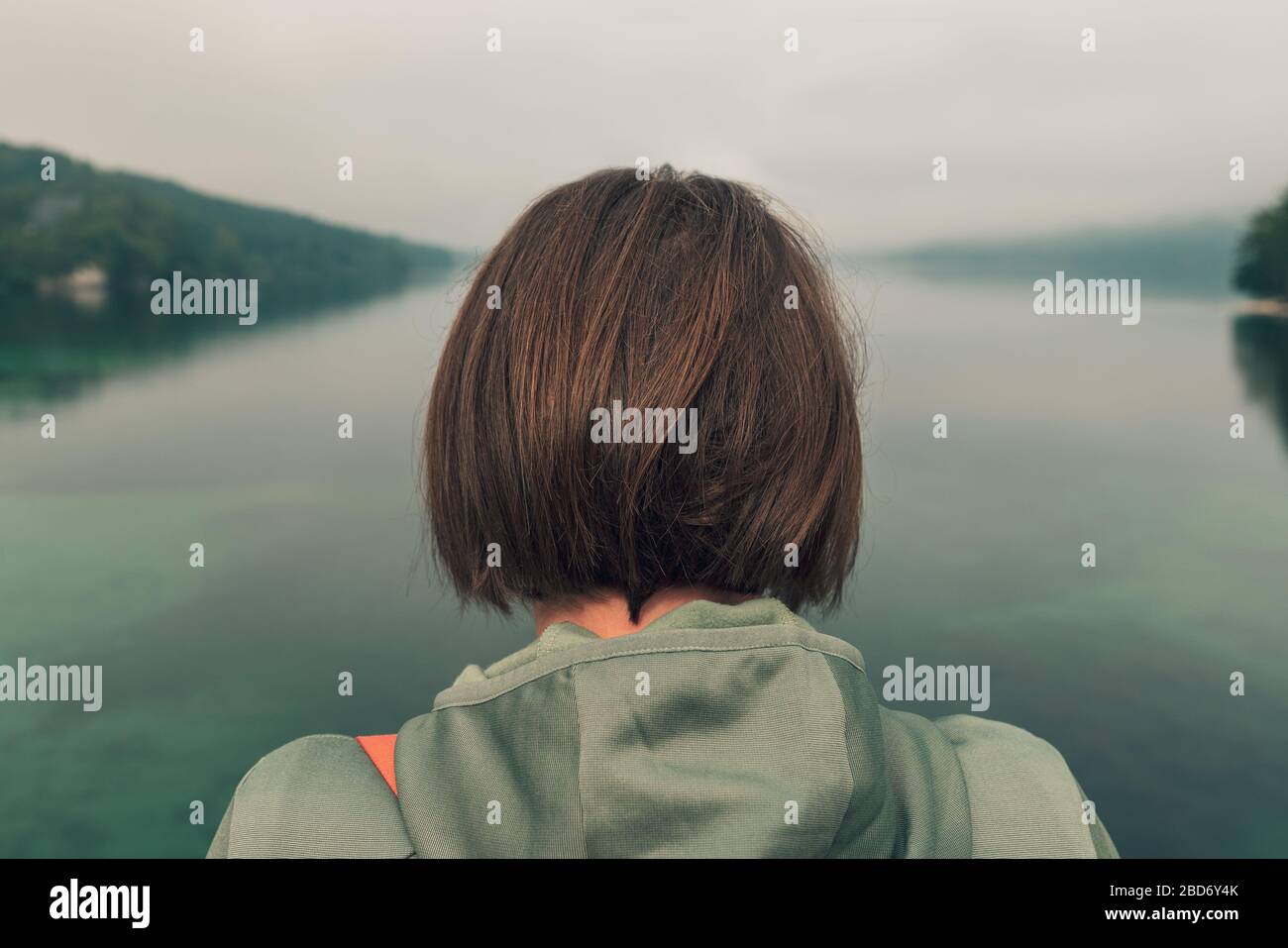 Weibliche Wanderer, die auf Brücke stehen und über den See schauen, Rückansicht der Frau in Sportbekleidung im Freien Stockfoto