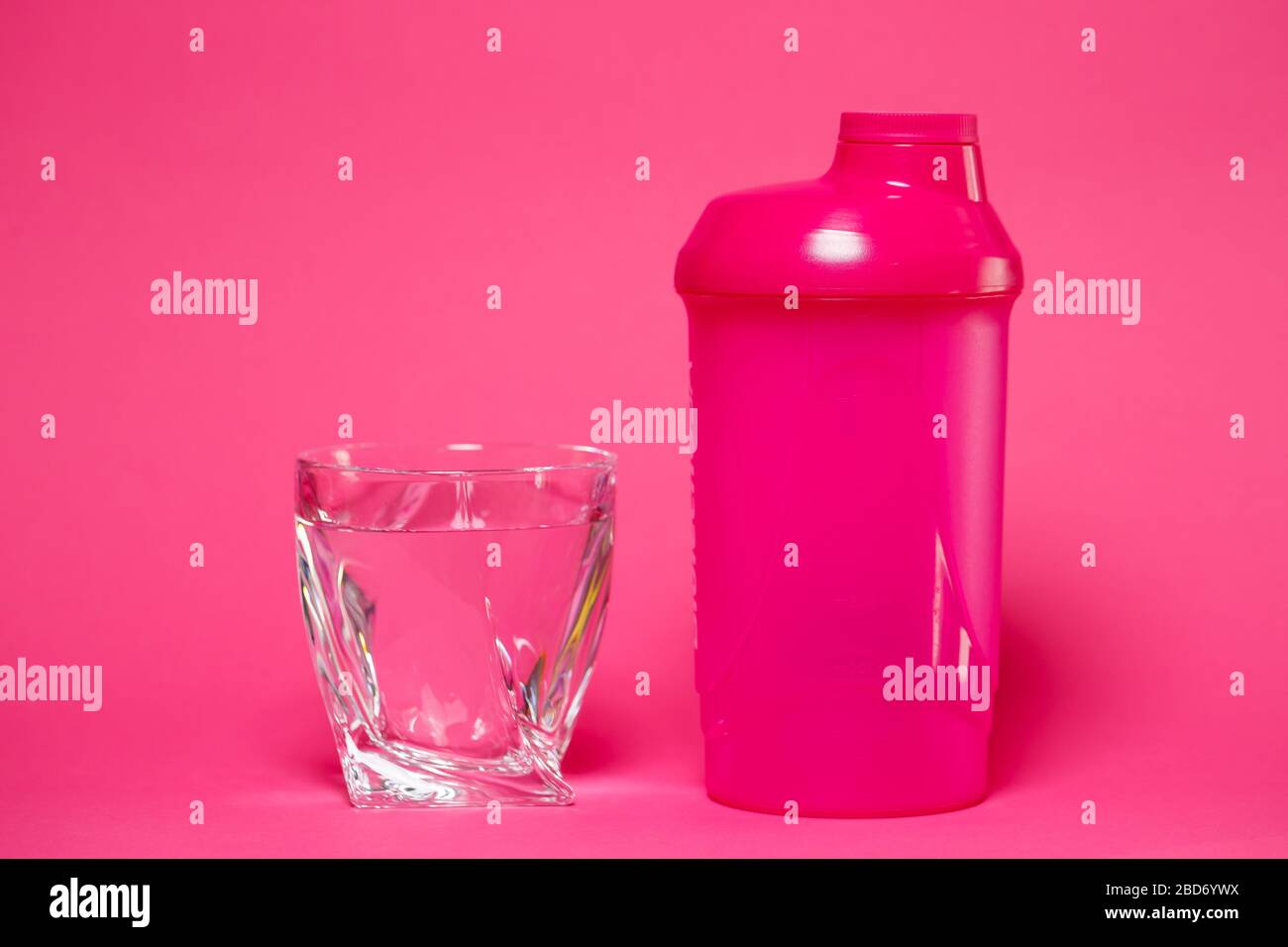 Rosa Shaker, Glas Wasser, farbigen Hintergrund, Sport, Energy Drink Stockfoto