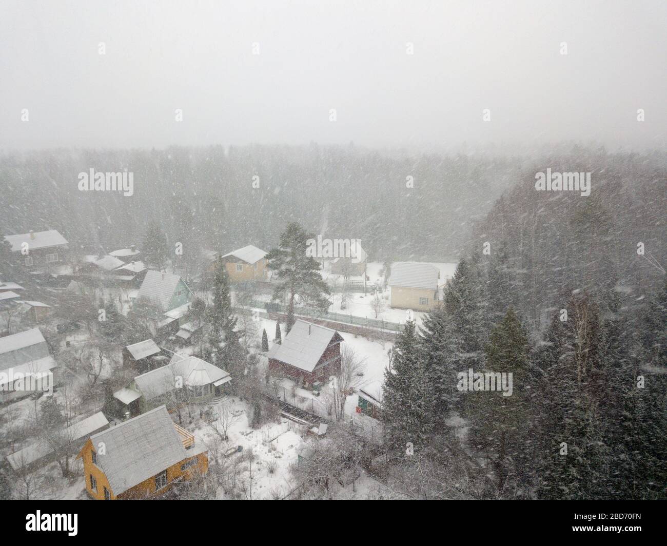 Luftaufnahme mit niedriger Sicht auf einen schrecklichen Schneefall über einem Twon Stockfoto
