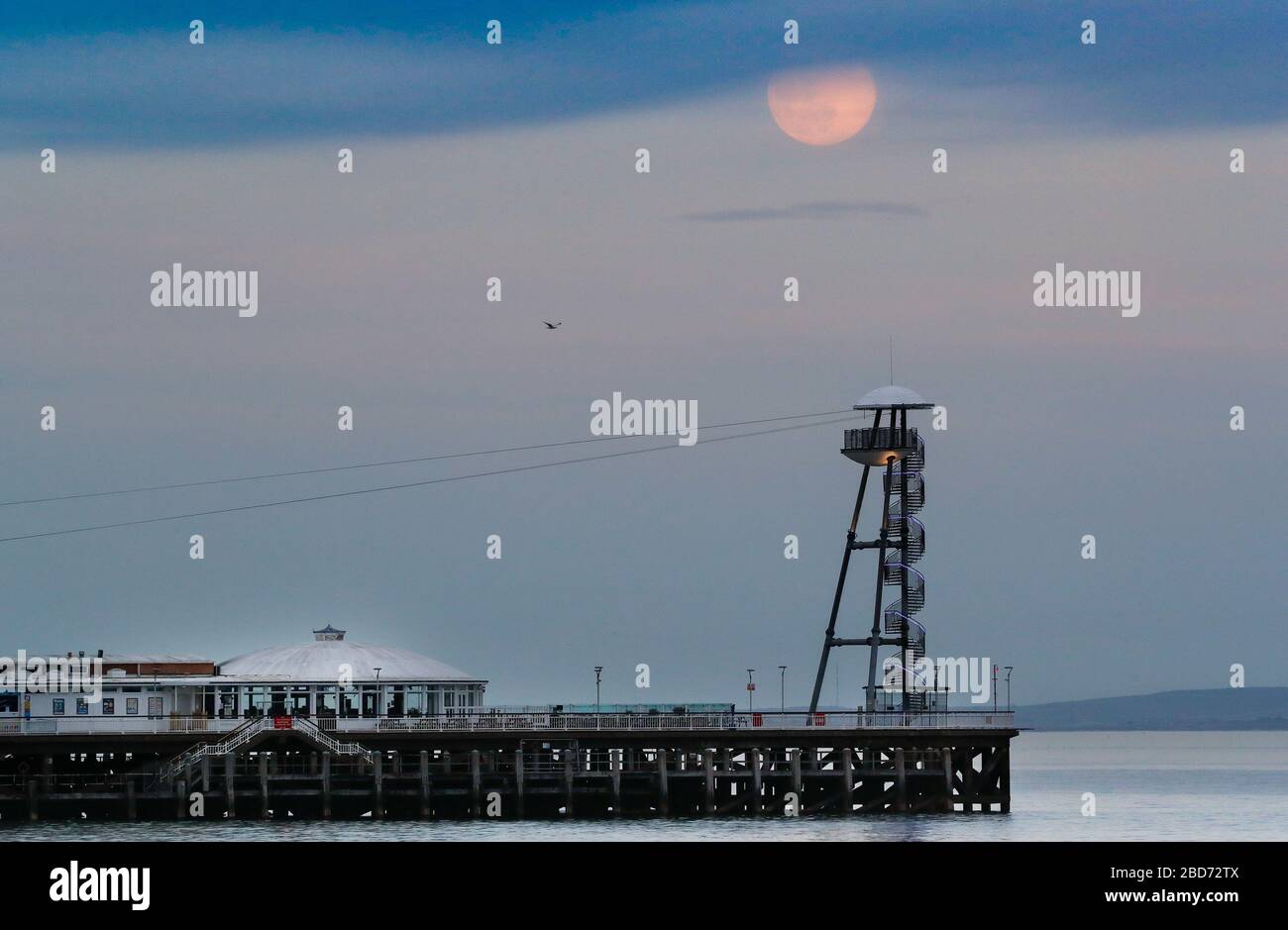 Bournemouth, Großbritannien. April 2020. Der Super Pink Moon erhebt sich über dem Bournemouth Pier in Dorset. Gutschrift: Richard Crease/Alamy Live News Stockfoto