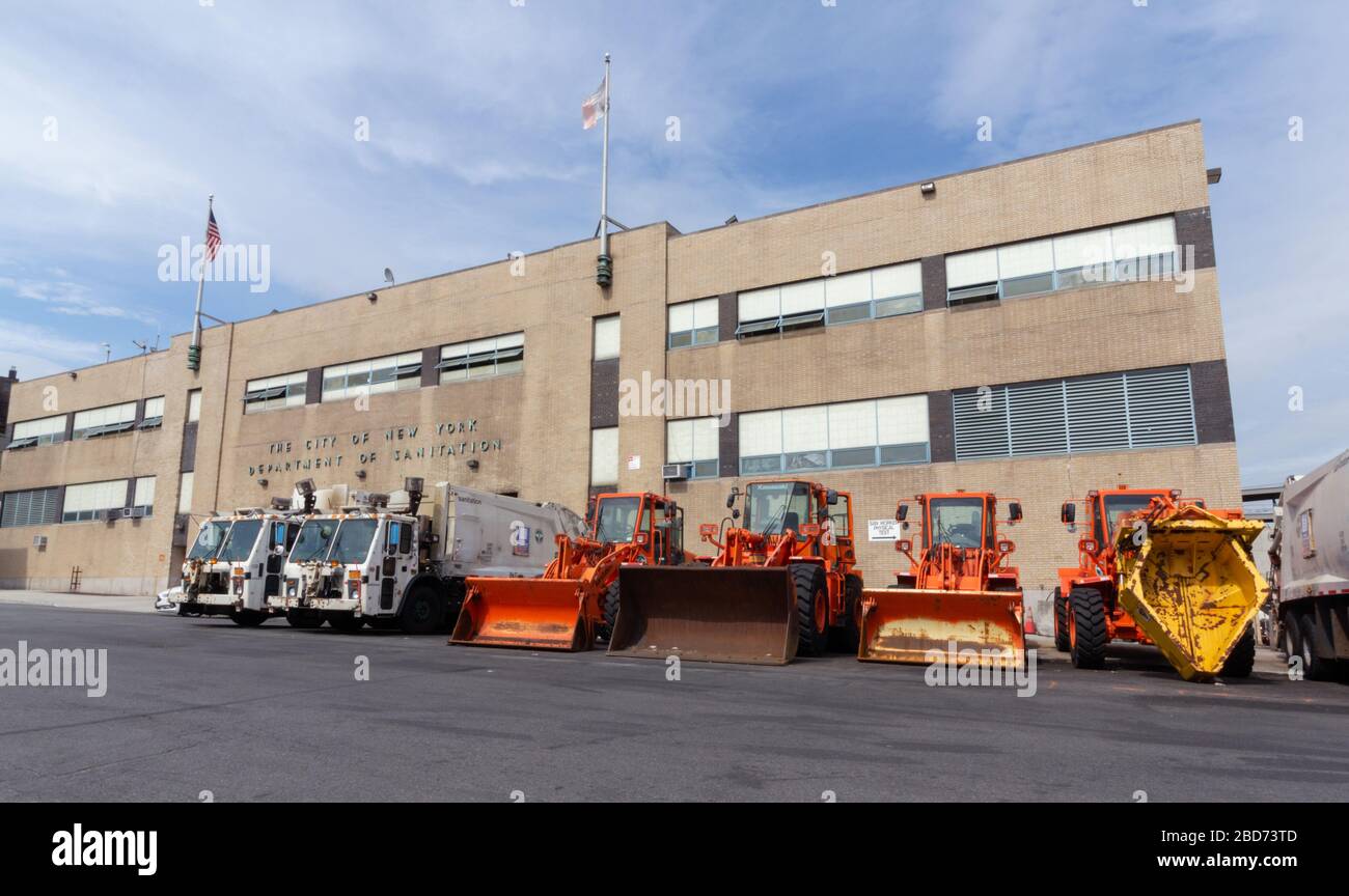 Verschiedene Arten von Sanitär-LKW oder Lastwagen für Müllbeseitigung und Schneeräumung in einem Depot der City of New York Department of Sanitation aufgereiht Stockfoto