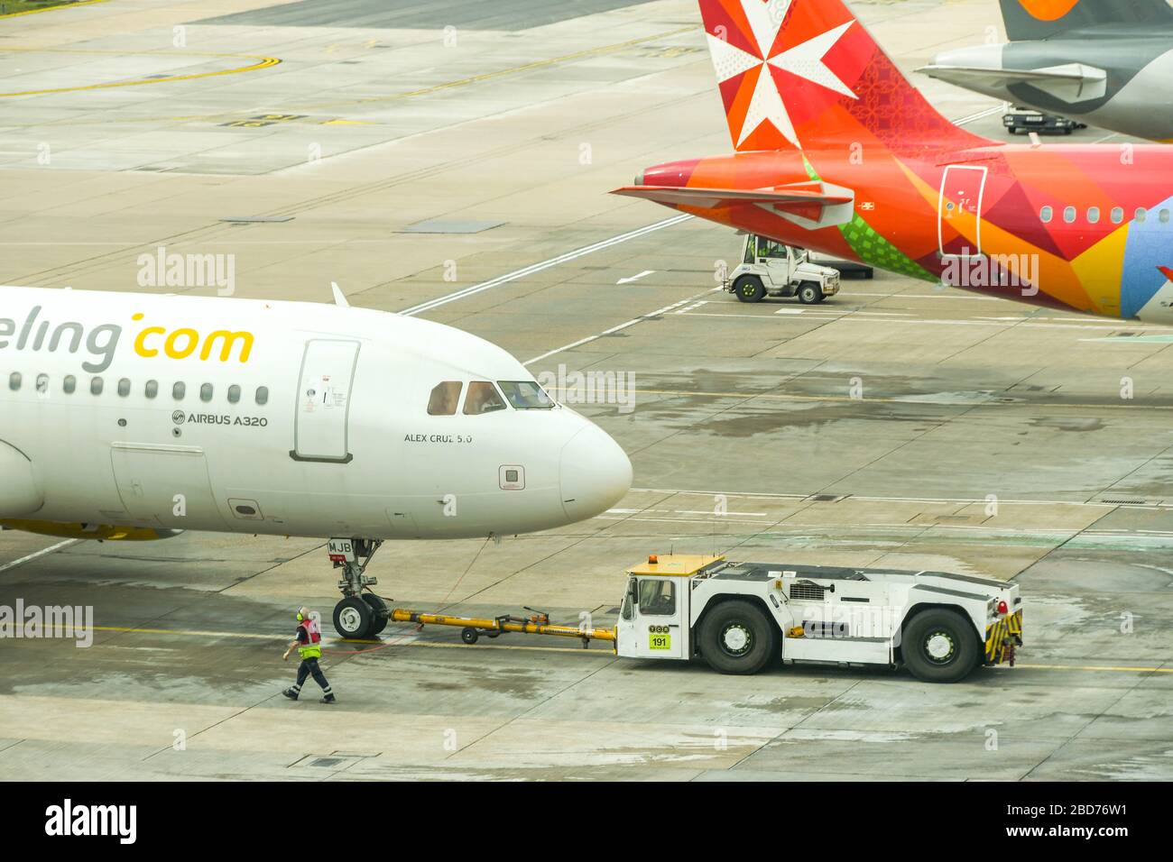 FLUGHAFEN LONDON-GATWICK - APRIL 2019: Airbus A320, der von der spanischen Fluggesellschaft Vueling betrieben wird, wird von einem Schlepper auf dem Flughafen London-Gatwick zurückgedrängt Stockfoto