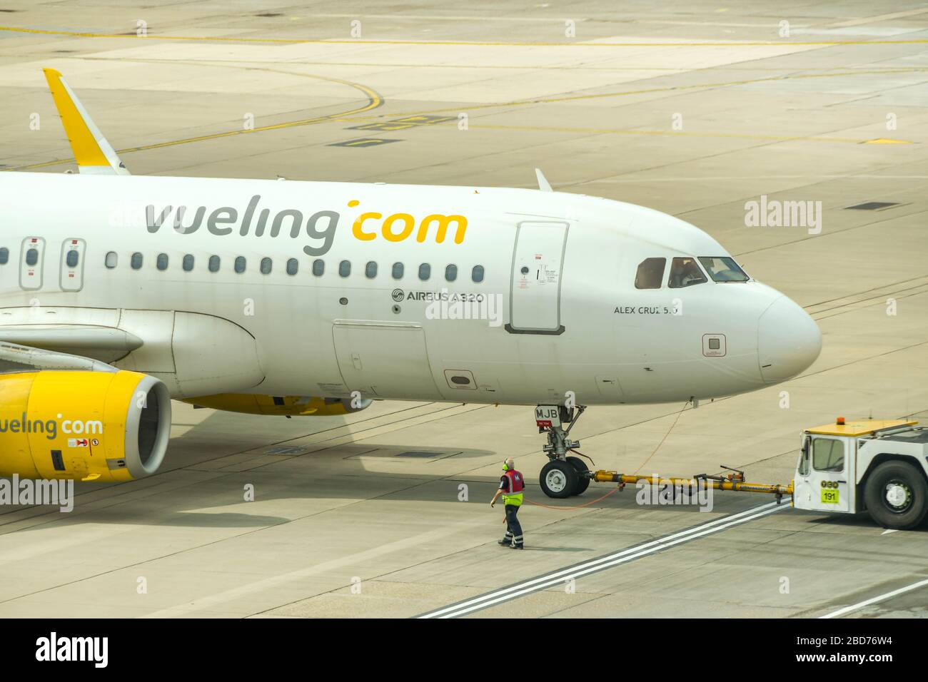 FLUGHAFEN LONDON-GATWICK - APRIL 2019: Airbus A320, der von der spanischen Fluggesellschaft Vueling betrieben wird, wird von einem Schlepper auf dem Flughafen London-Gatwick zurückgedrängt Stockfoto