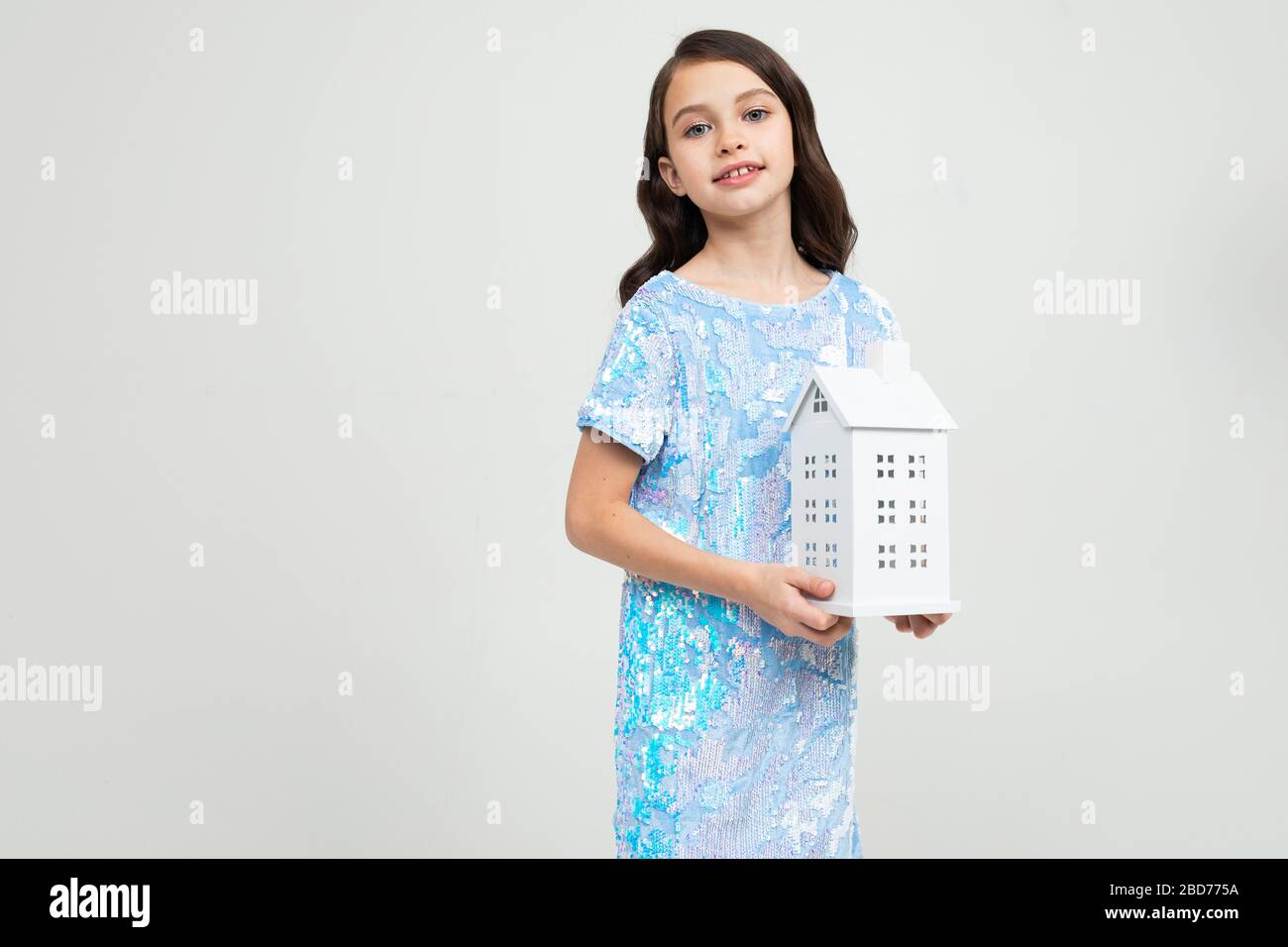 Teenager-Mädchen mit einer Figur zu Hause auf weißem Hintergrund mit Kopierraum. Unbewegliches Eigentum Stockfoto